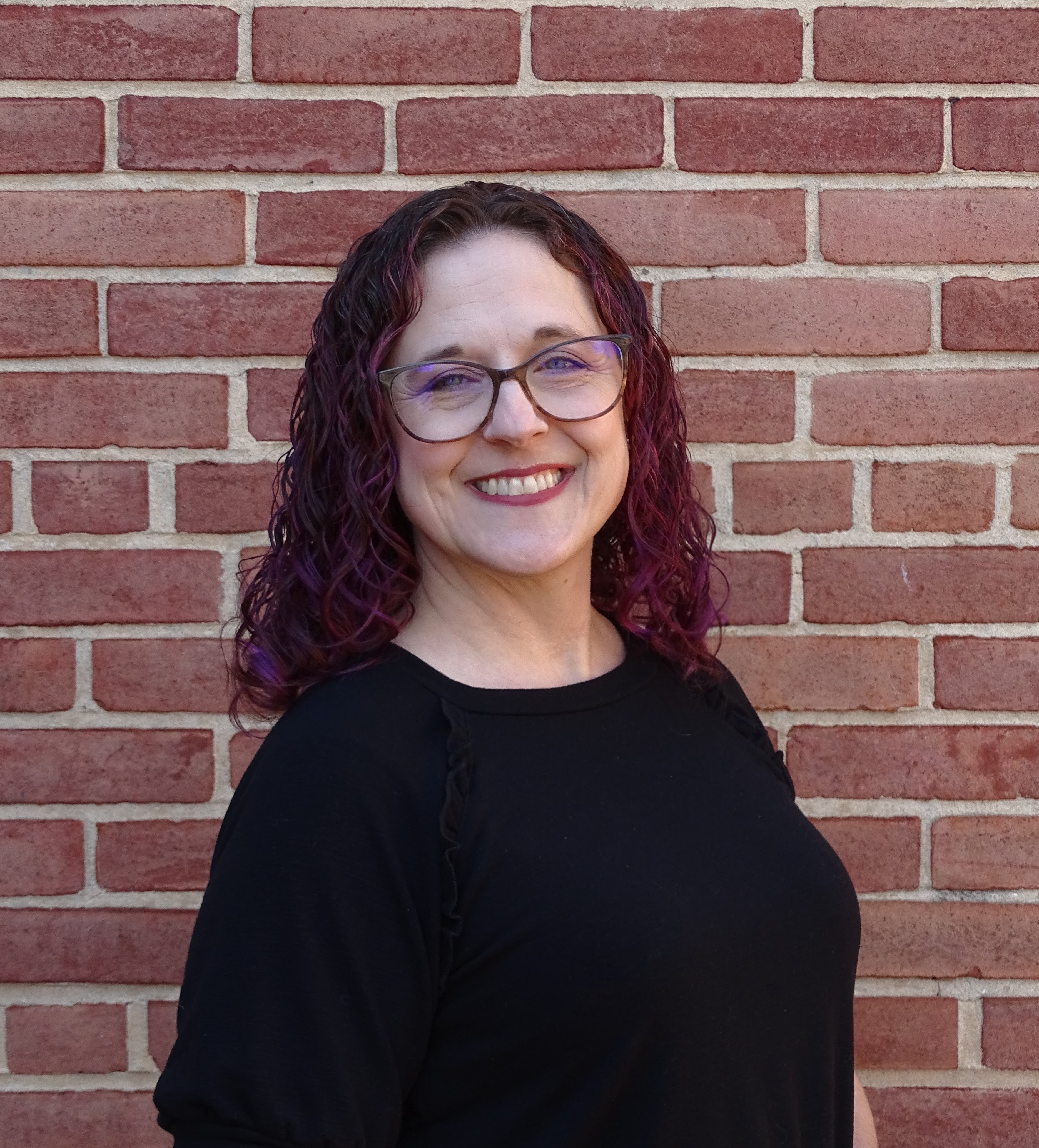 portrait of woman in front of brick wall