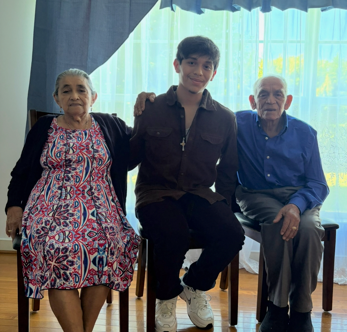 Photo of Frank Rodriguez and two family members sitting in a living room