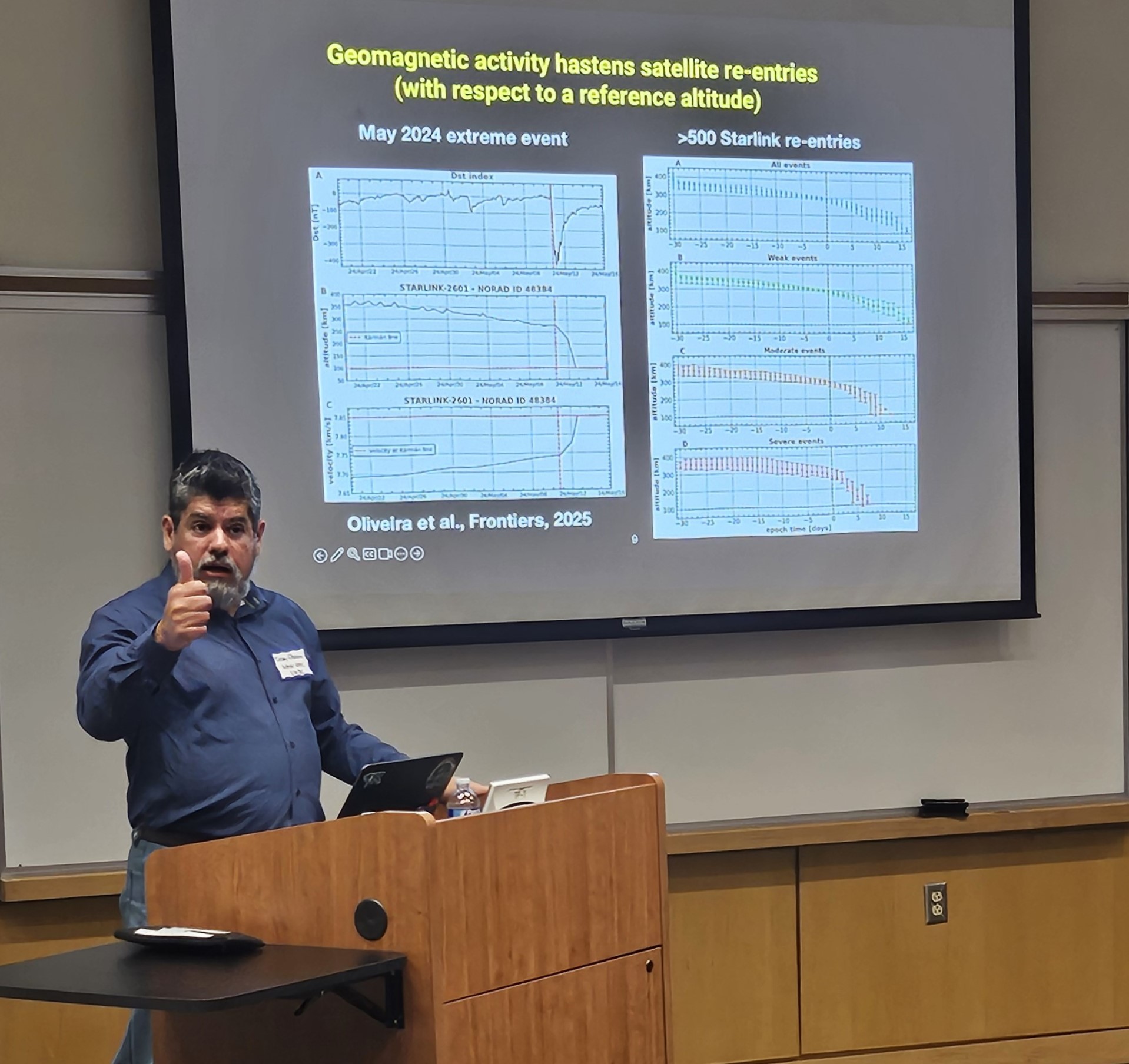 Denny stands at podium with slide projected behind him titled Geomagnetic activity hastens satellite re-entries, comparing May 2024 extreme event to >500 Starlink re-entries