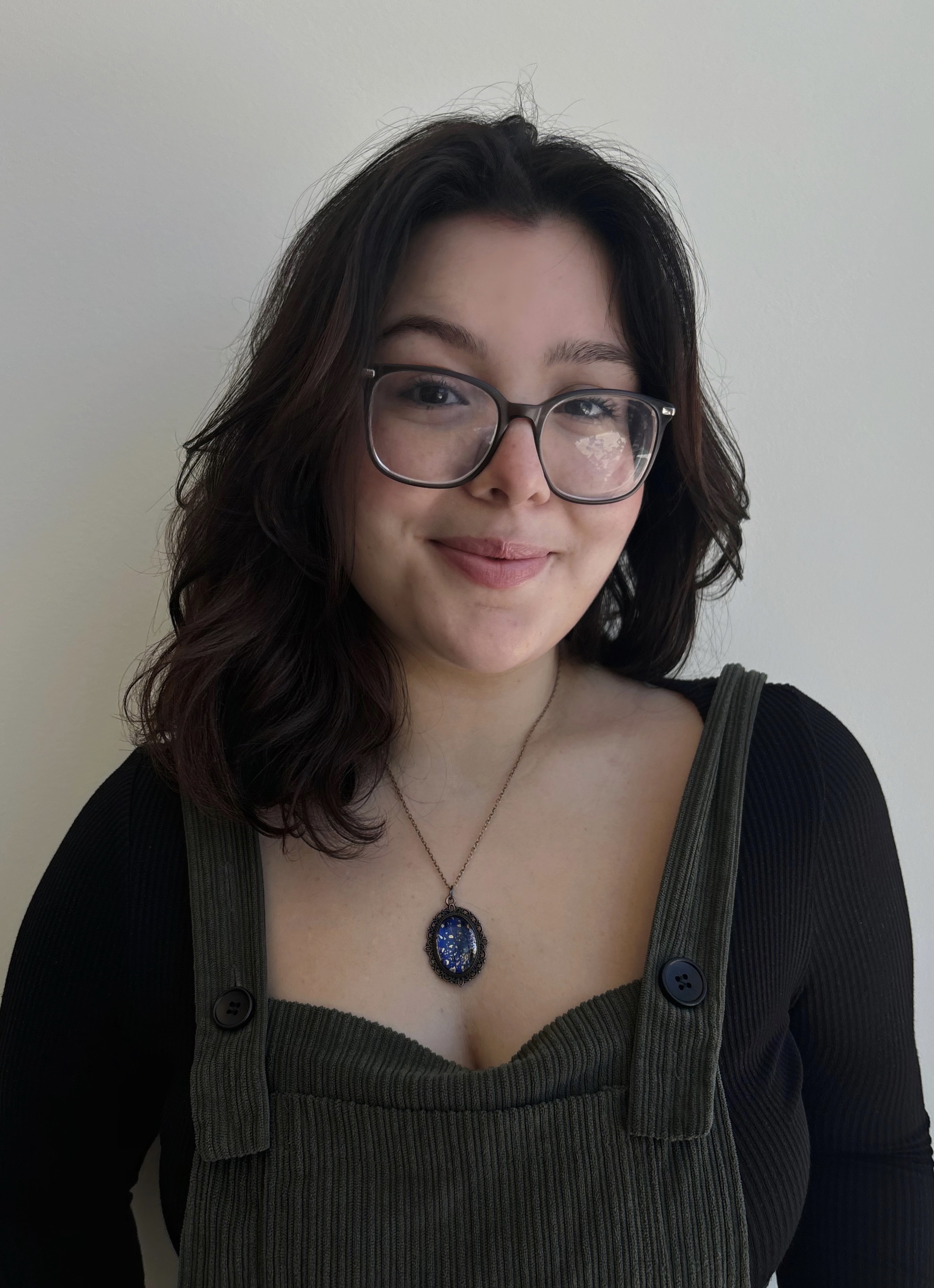 Headshot of INDS student worker Amanda wearing glasses, in a black top smiling