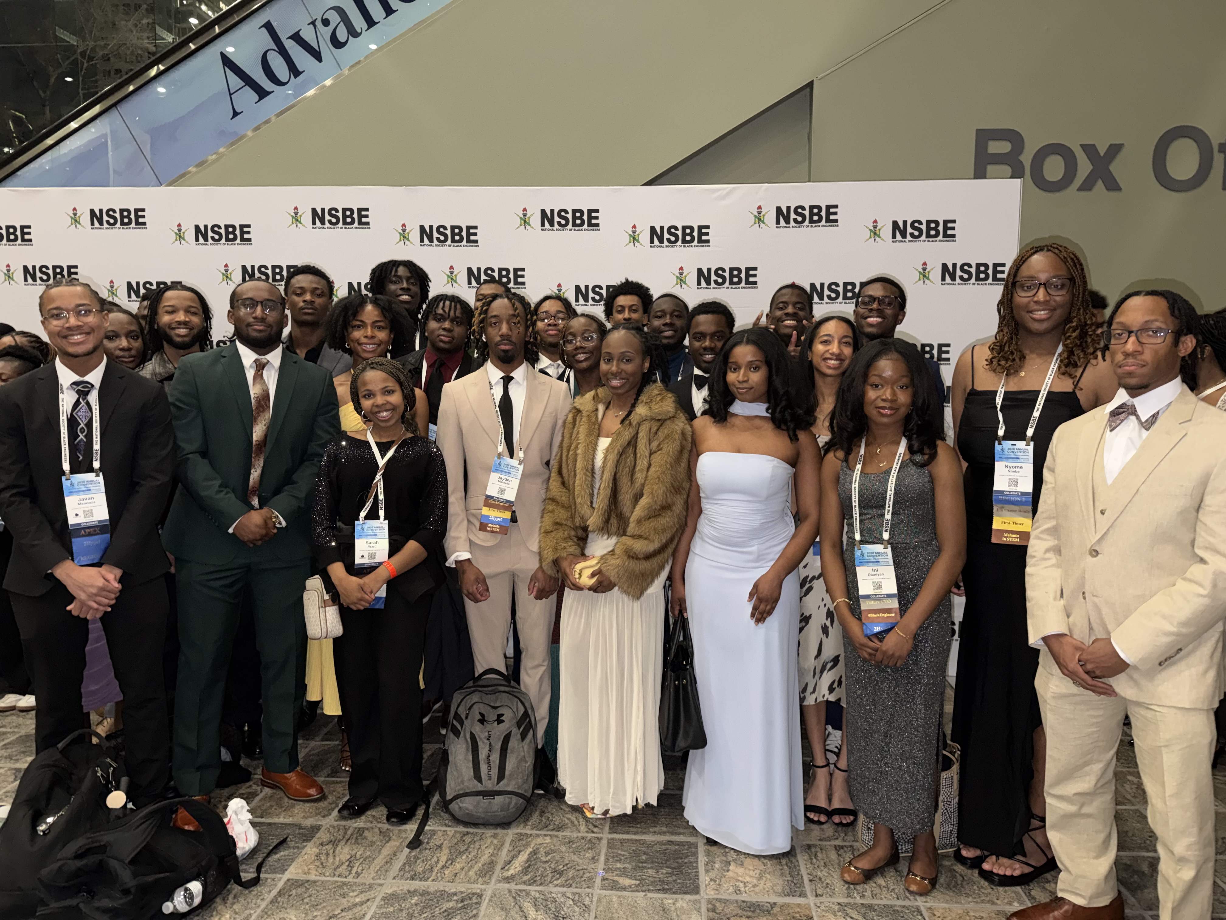 Group of students standing in front of the NSBE sign, dressed to impress at the Golden Torch Award