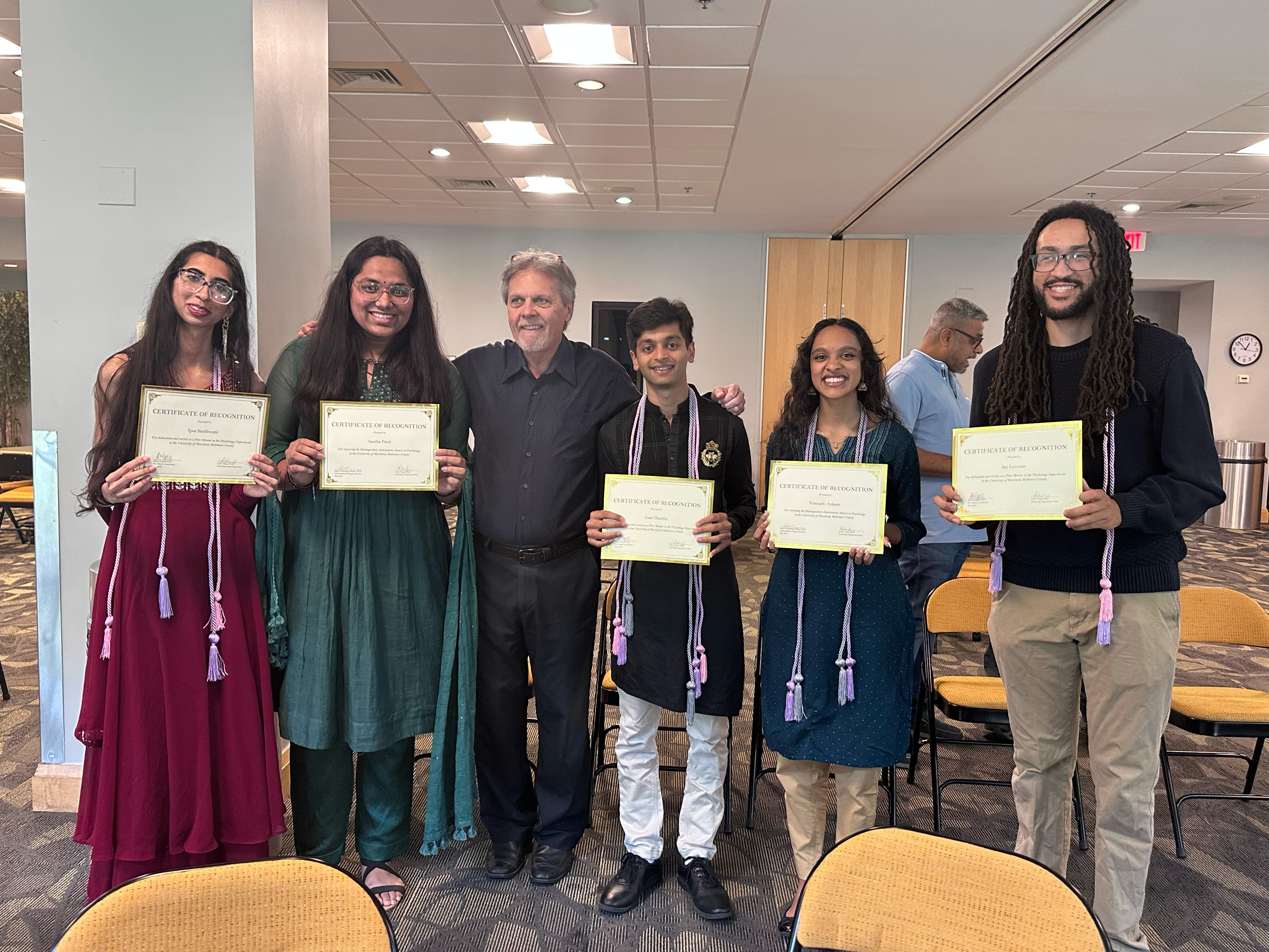 Professor standing with 5 undergraduate student award winners