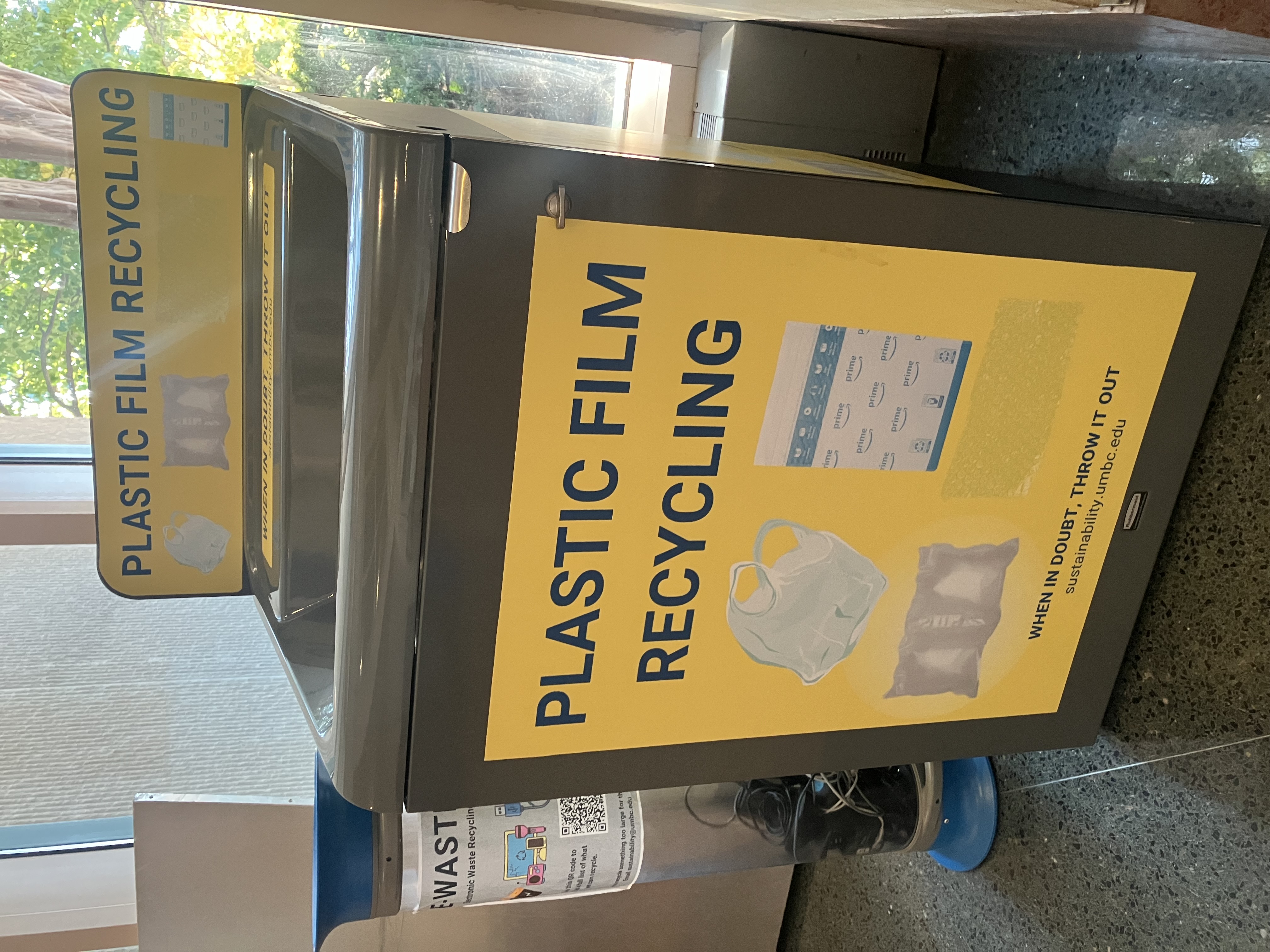 large yellow bin with plastic bag icons on the front and top