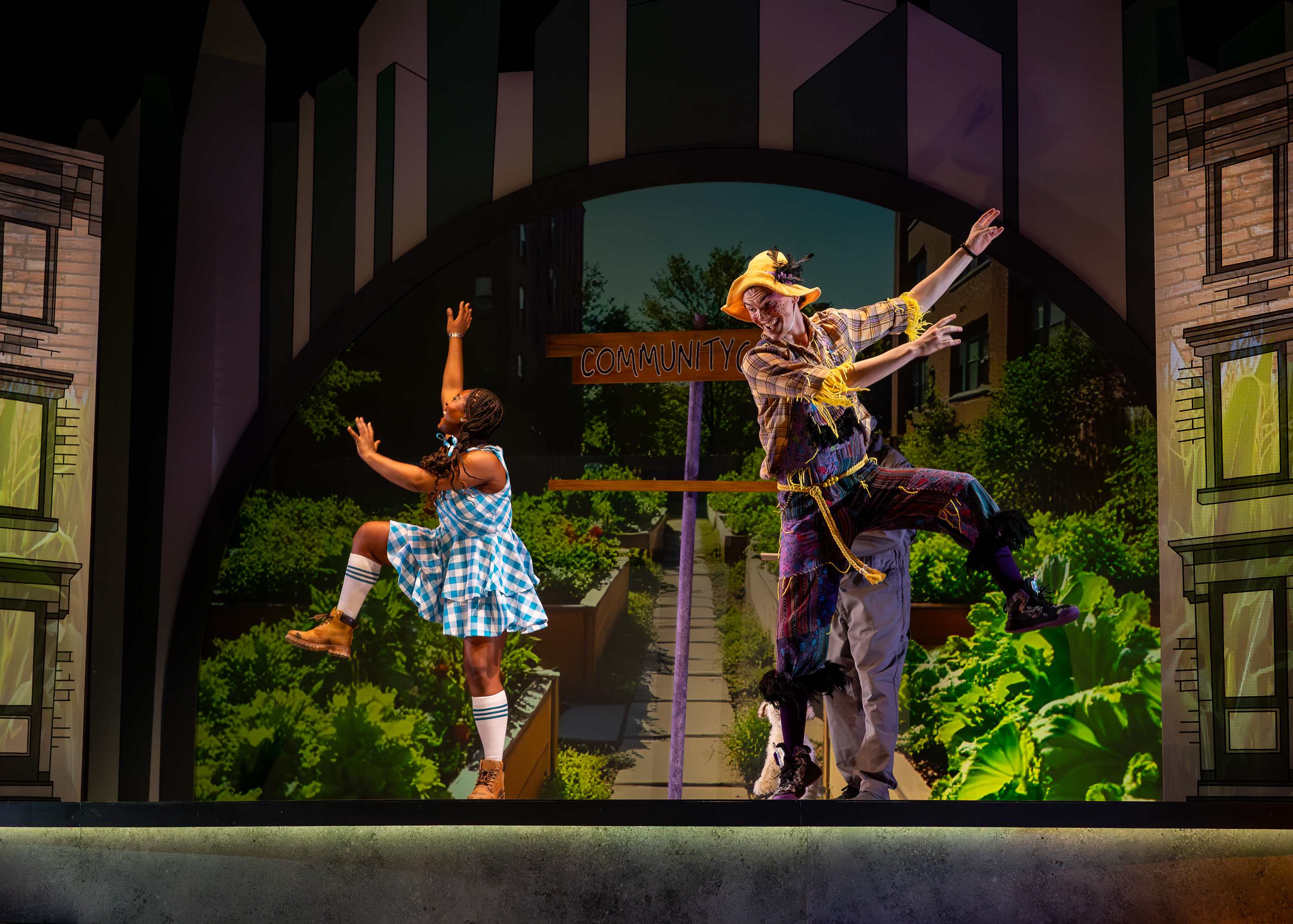 Production photo from The Wonderful Wizard of Oz. Dorothy and the Scarecrow dance in the Scarecrow's garden.