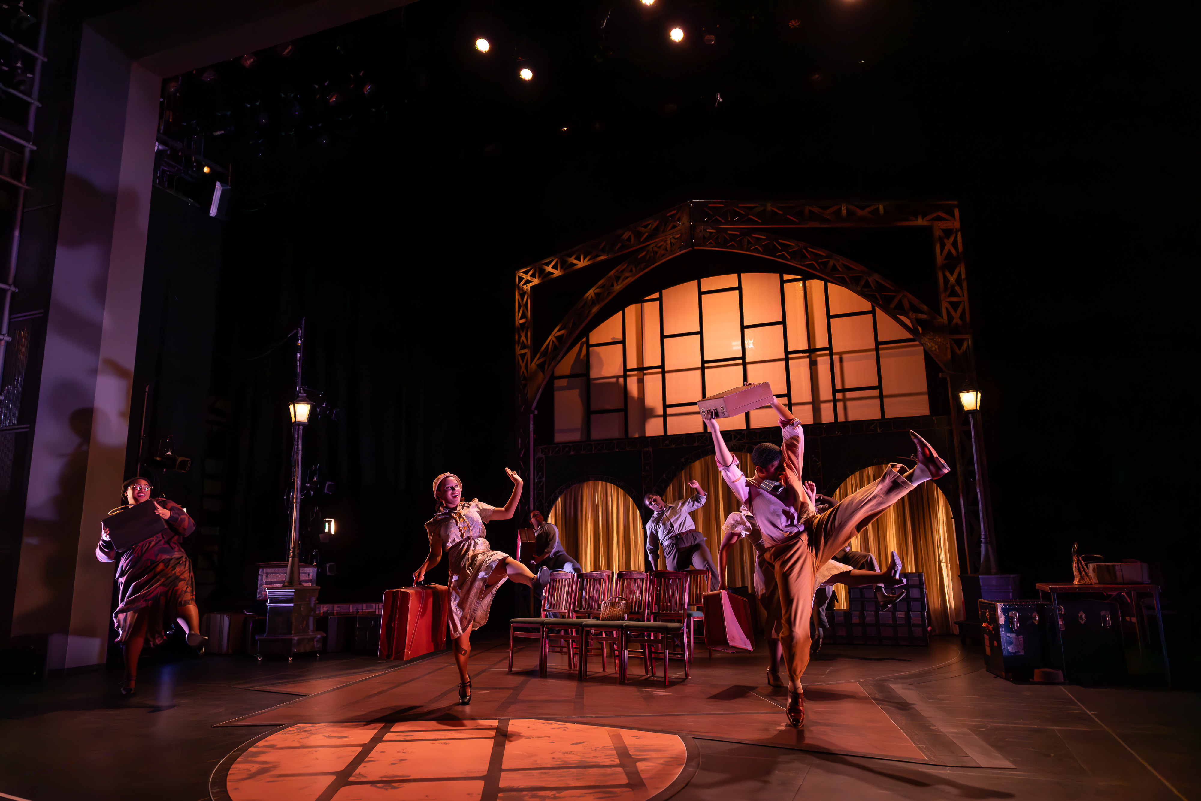 Production Photo from Shakespeare in Harlem. The ensemble dances with suitcases.