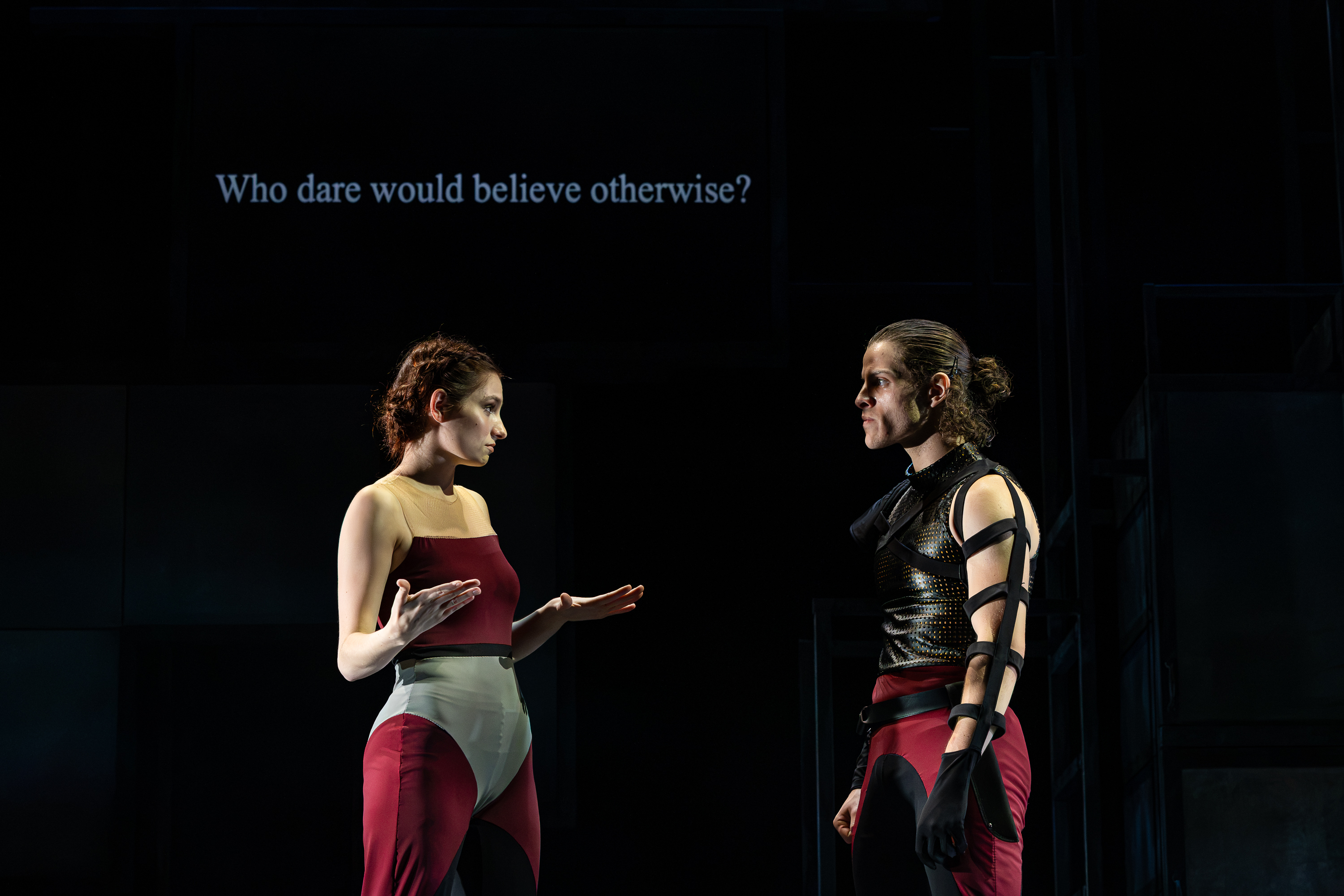 Production photo of Lady Macbeth speaking in American Sign Language to Macbeth. The supertitle reads "Who dare would believe otherwise?"