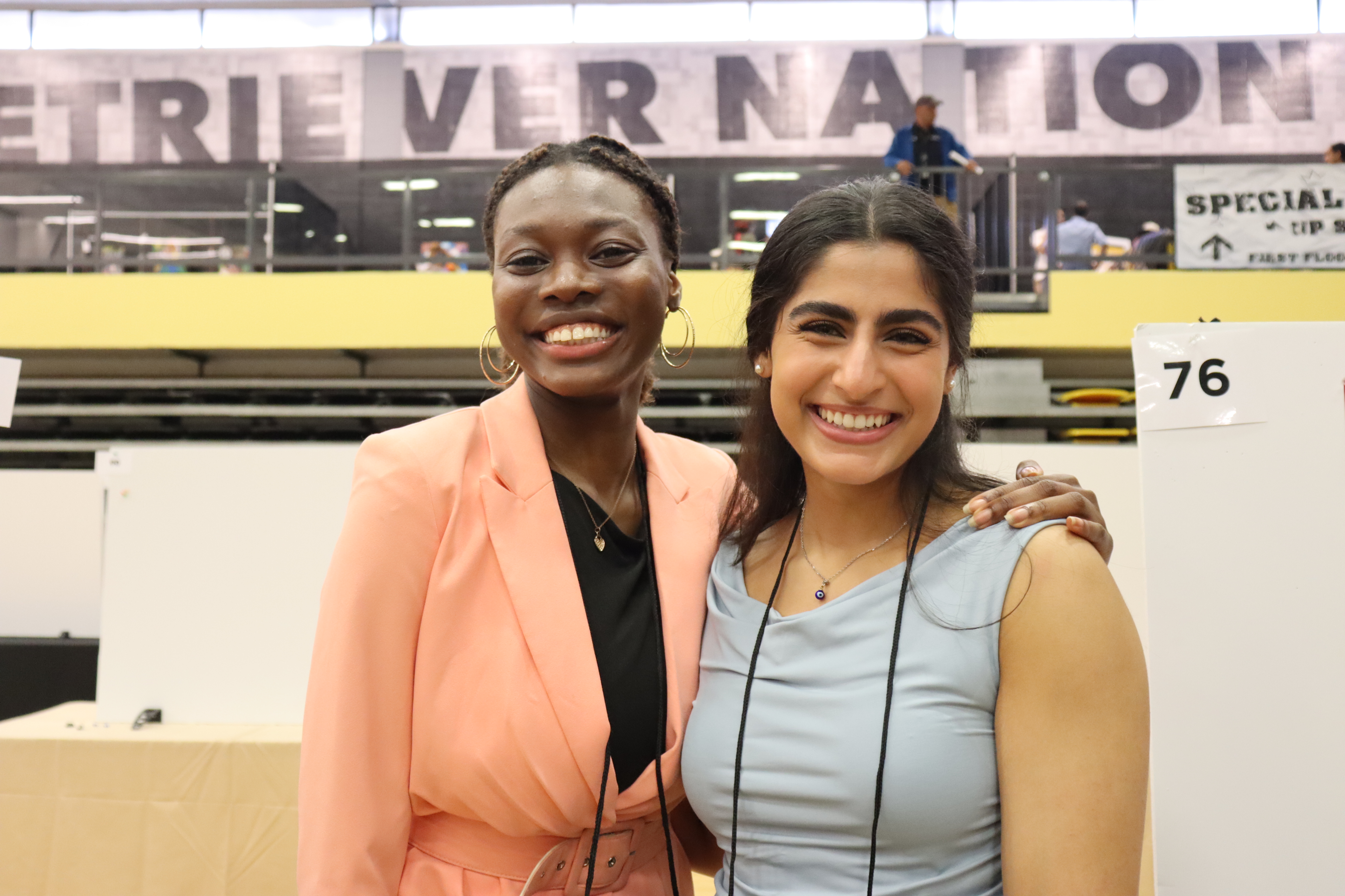 Joanna and Shreya smiling with the words Retriever Nation in the background