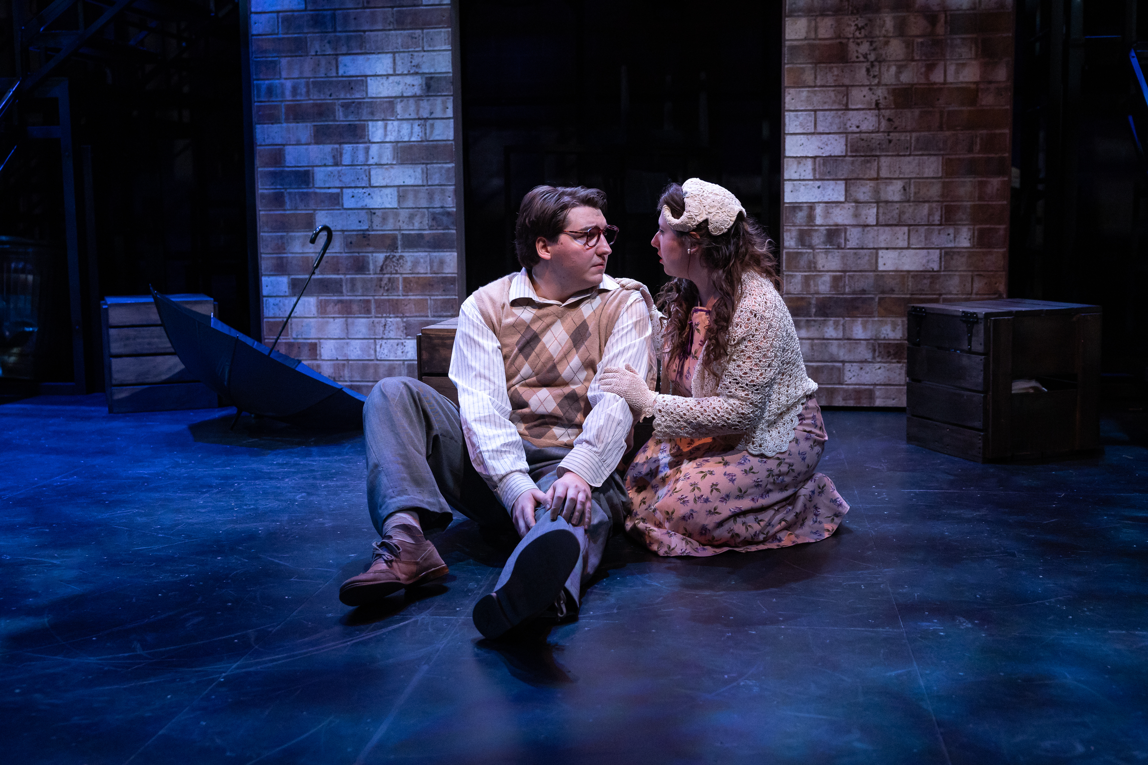 Production Photo from Street Scenes. The performers playing Sidney Kaplan and Doris sit on the floor and look at each other.