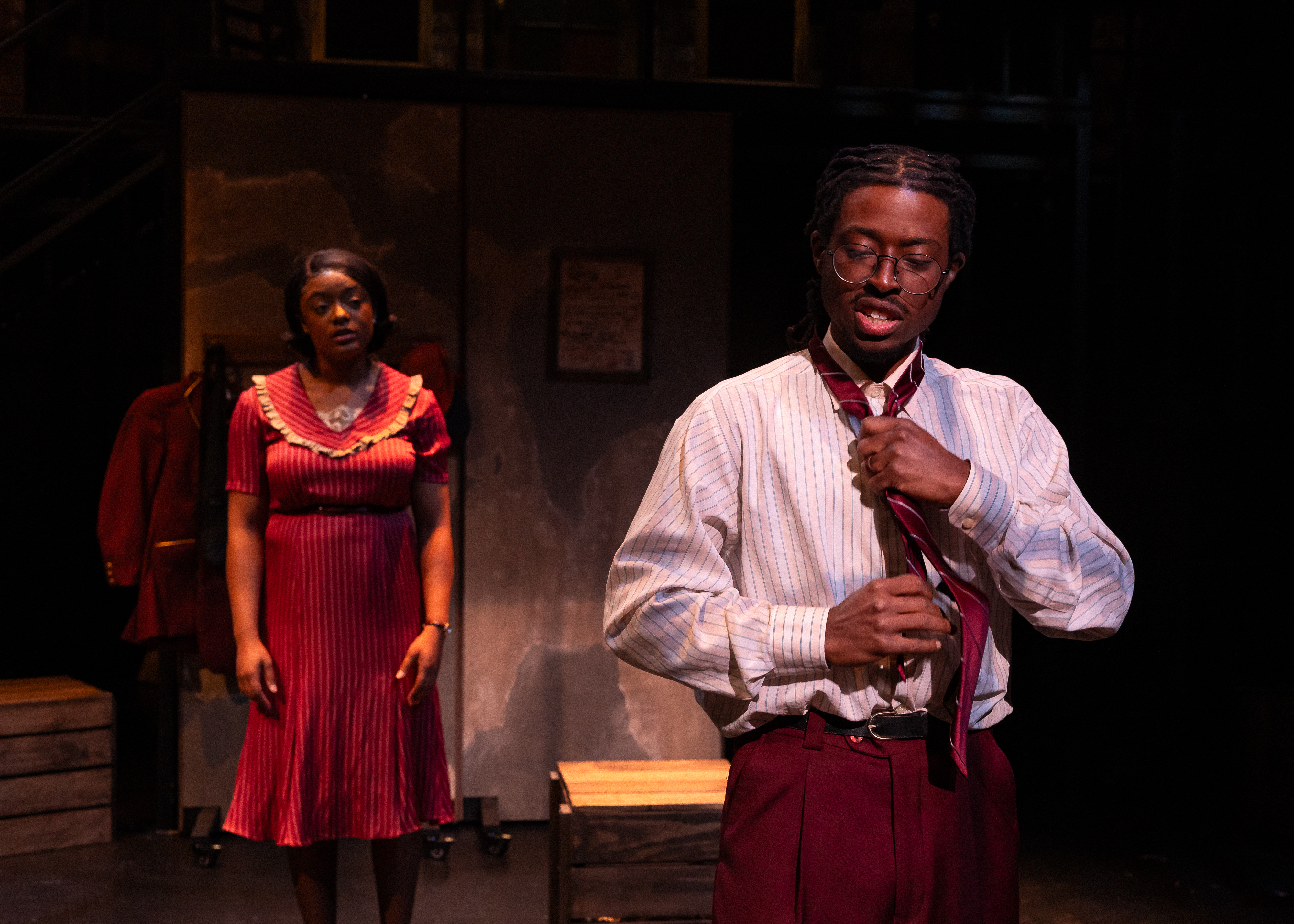 Production Photo from Street Scenes. The performers playing Mamie and Jim Jackson argue. Jim stands in the foreground adjusting his tie.