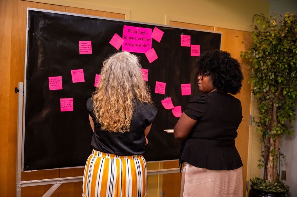 Photos of two staff members working collaboratively in front of a blackboard