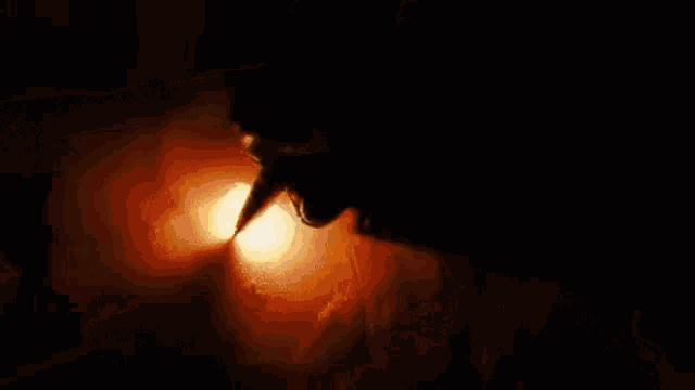A person writing on a piece of paper with a pen. The pen catches everything on fire as it is used.