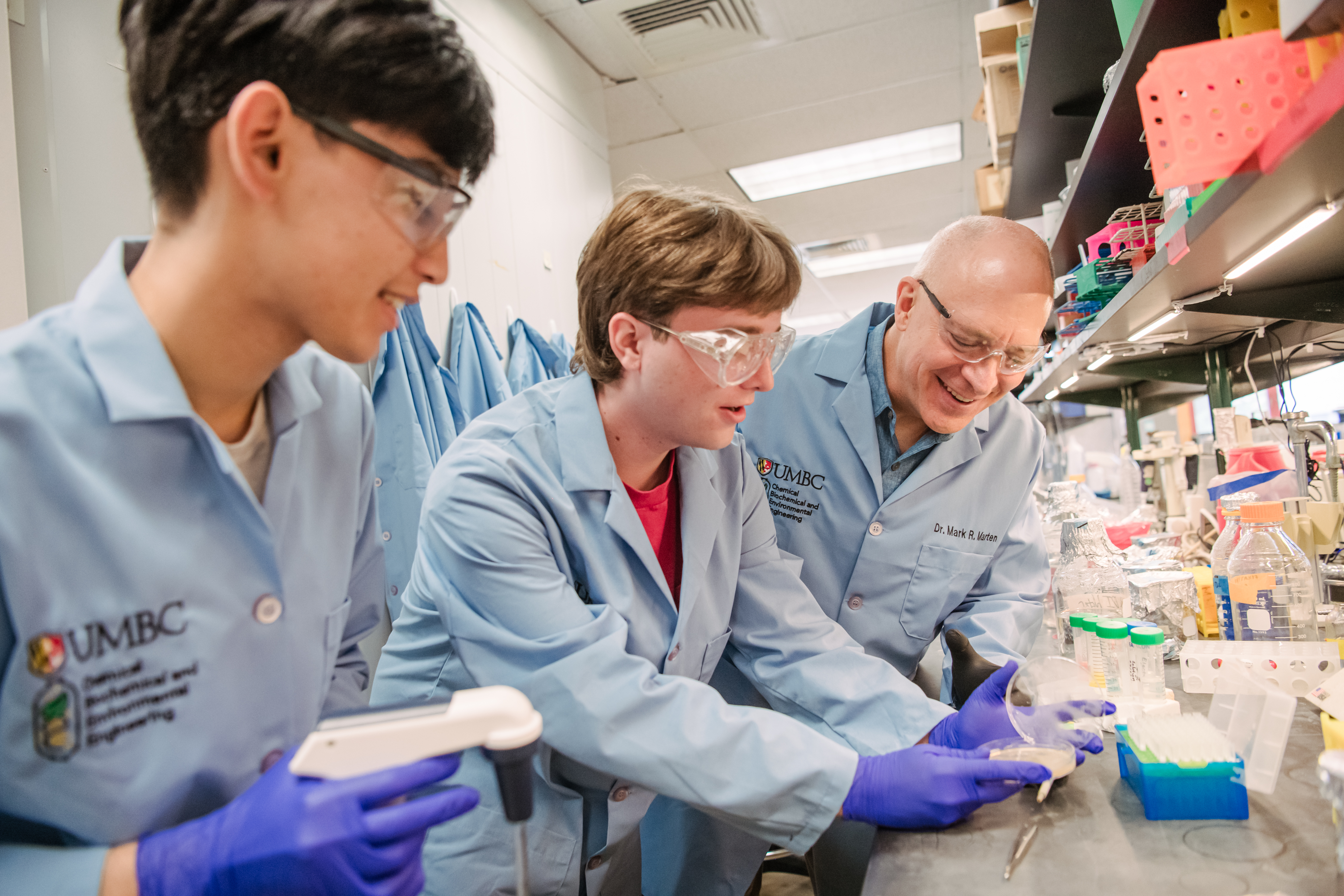 Photo: Mark Marten (right) with students Matthew Quintanilla (left), Garrett Hill (center) and in the lab. (Marlayna Demond '11/UMBC)